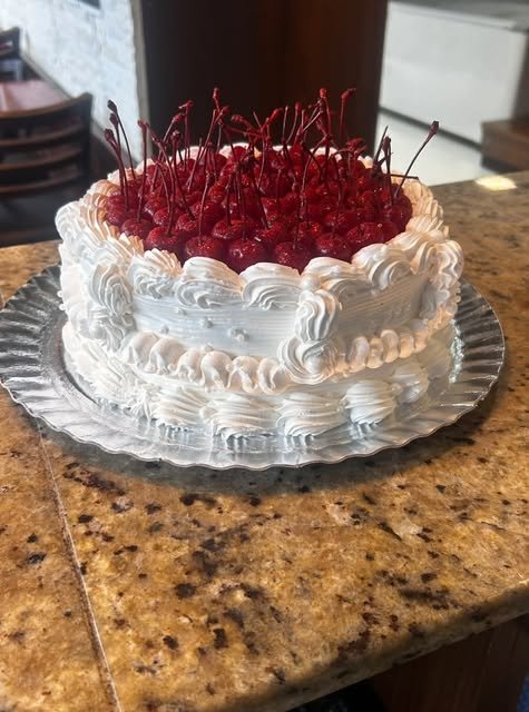 Bolo branco decorado com cerejas