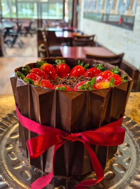 Bolo de chocolate com morangos e laço vermelho