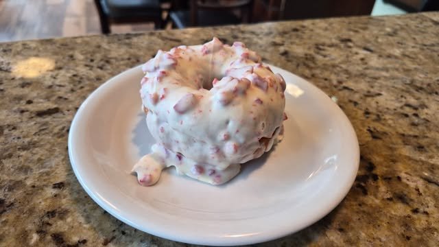 Donut com cobertura branca e pedaços rosa